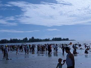 Wisatawan Manfaatkan Libur Lebaran Mandi di Pantai Zakat