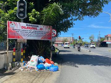 Sampah dibuang Tepat di Bawah Spanduk Larangan