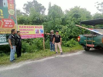 Satpol PP Pasang Spanduk Wajib Busana Muslim