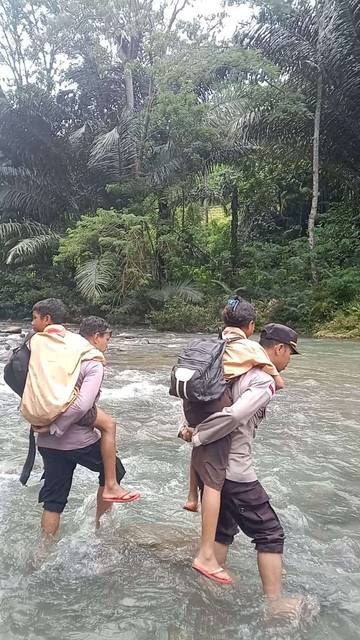 Polisi Gendong Siswa Seberangi Sungai Wae Songka