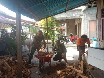 ​Babinsa Miangas Bantu Warga Angkut Kayu Bakar